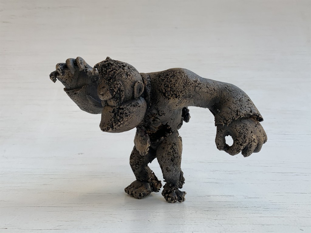 side view - a bronze sculpture of a gorilla-like character